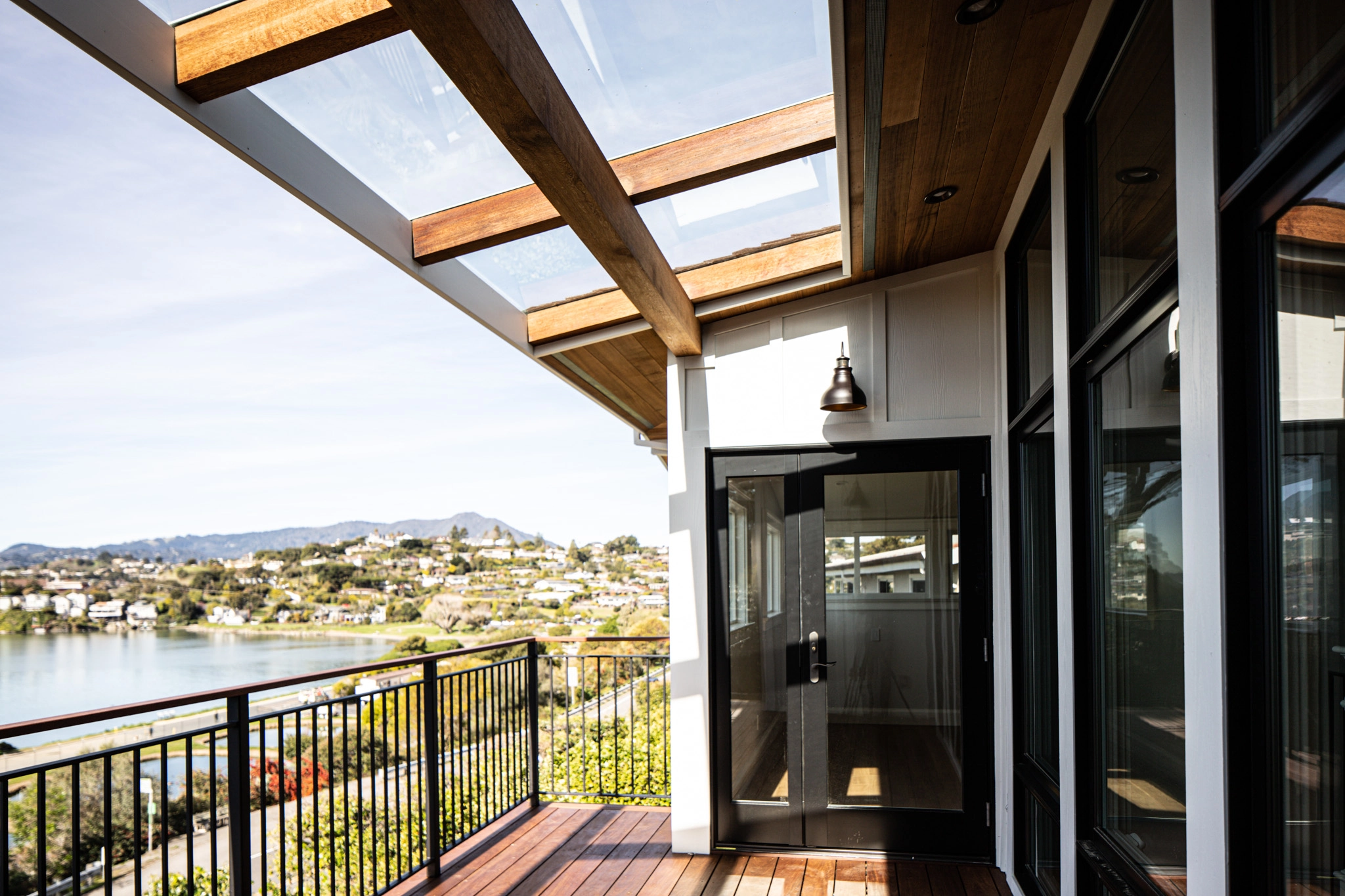 A context-driven architectural design featuring a covered balcony with panoramic bay views.