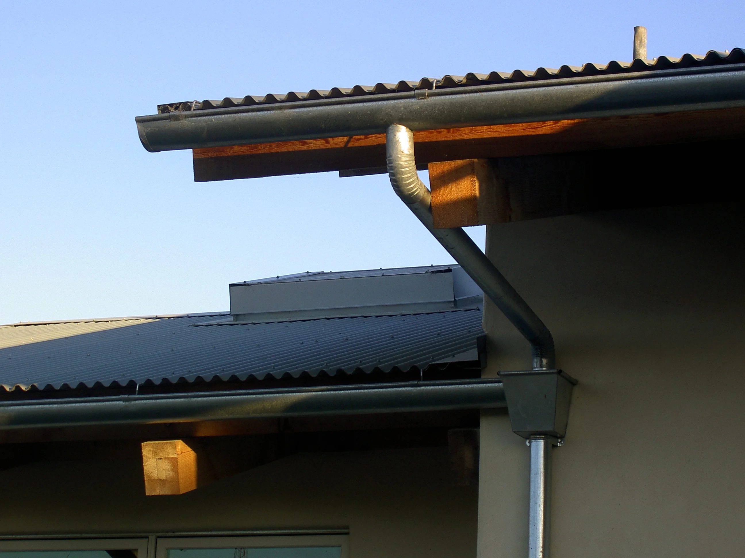 Architectural detail of site-responsive modern roofline and exposed timber framing.